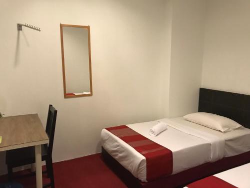 a small bedroom with a bed and a mirror at HL HOTEL Kota Bharu in Kota Bharu