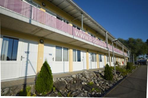a building with white doors and a sign on it at Hotel Bodensee-Arena in Kreuzlingen