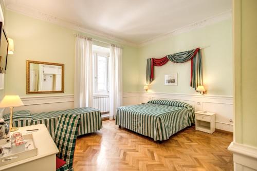 Cette chambre comprend 2 lits et un miroir. dans l'établissement Residenza Italia, à Rome