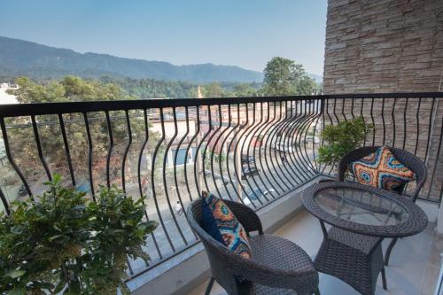 a balcony with two chairs and a table on a fence at HOLYWATER Hotel by Ganga Kinare #150 mts from Ganga Ghat Rishikesh in Rishīkesh