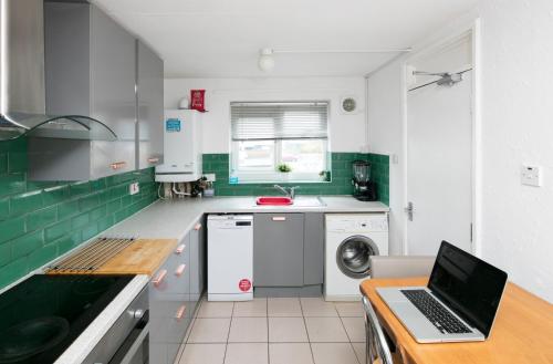 a kitchen with a laptop computer on a counter at New Cross Hospital - 4 Bedrooms, 2 Bathrooms, Free Parking in Wolverhampton
