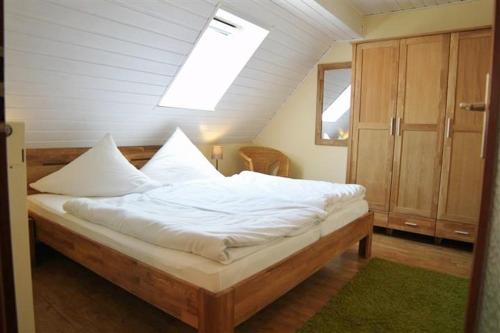 a bedroom with a large bed with white sheets at Ferienhof Stadtländer in Mardorf am Steinhuder Meer in Neustadt am Rübenberge