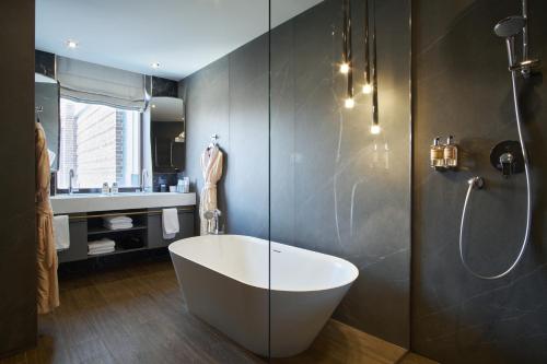 a bathroom with a bath tub and a shower at ARKA Hotel by Ginza Project in Rostov on Don