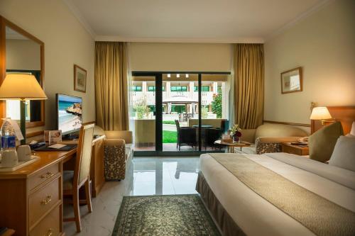 a hotel room with a bed and a desk at Golden Tulip Nizwa Hotel in Nizwa