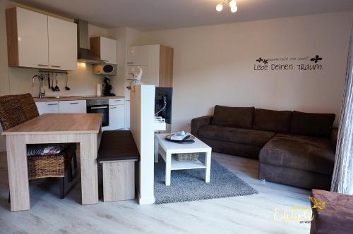 cocina y sala de estar con sofá y mesa en FeWo Seeseite, en Rieden