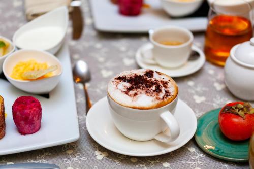 a cup of coffee on a plate on a table at Relais Briuccia e Ristorante Capitolo Primo in Montallegro