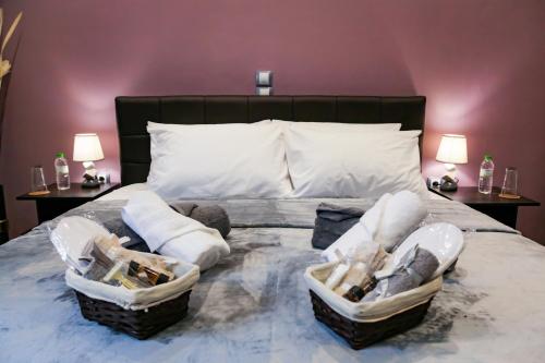 a bedroom with a bed with baskets of towels at Athens OwlCity in Athens