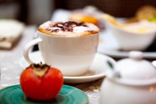 a cup of coffee and a tomato on a table at Relais Briuccia e Ristorante Capitolo Primo in Montallegro
