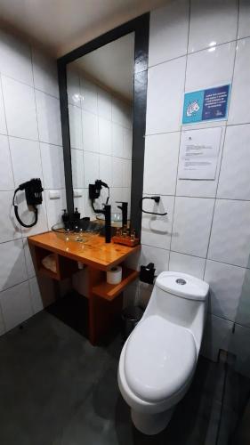 a bathroom with a toilet and a wooden desk at Treca Rupan Lodge in Neltume