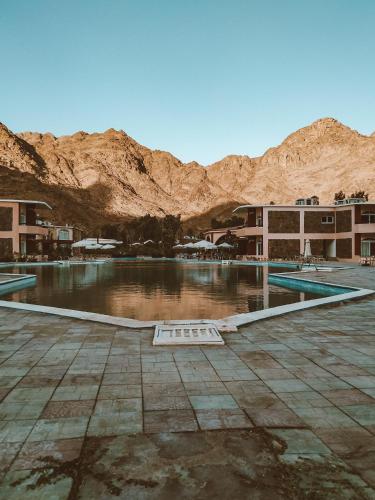 a pool of water with mountains in the background at Morgenland Holly Village in Saint Catherine