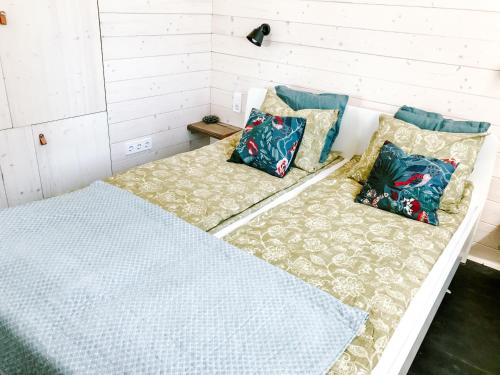 a bed with pillows on it in a room at Wine & Space Lodge at Lake Balaton in Balatonlelle