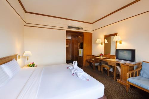 Habitación de hotel con cama y TV en Betong Merlin Hotel, en Betong