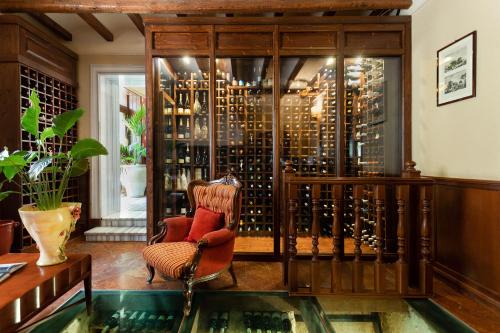a room with a chair and a glass case with wine bottles at Relais Briuccia e Ristorante Capitolo Primo in Montallegro