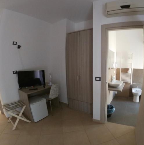 a bathroom with a desk and a toilet and a television at B&B A Due Passi in San Giovanni Gemini