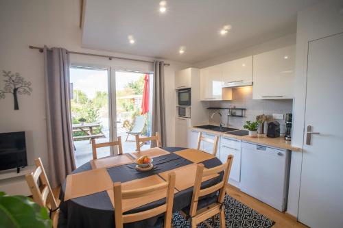 a kitchen and dining room with a table and chairs at Le jardin des 4 saisons in Le Mans