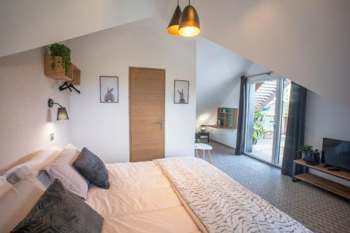 a bedroom with a large bed and a television at Le jardin des 4 saisons in Le Mans