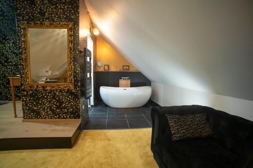 a bathroom with a large mirror and a bath tub at Le jardin des 4 saisons in Le Mans