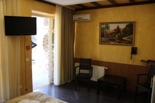 a hotel room with a bed and a television on the wall at MishyN-City Hotel in Dobrovlyany