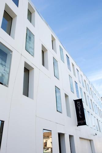a white building with a black sign on it at Seeko'o Hotel Bordeaux in Bordeaux