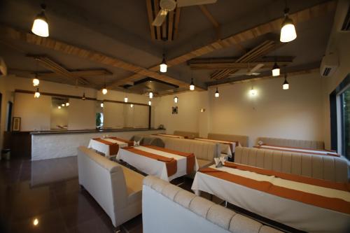 a restaurant with couches and tables in a room at Virat Resorts, Sariska Rajasthan in Bairāt
