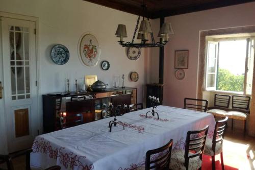 a dining room with a white table and chairs at Casa do Lagar de Medelim in Medelim