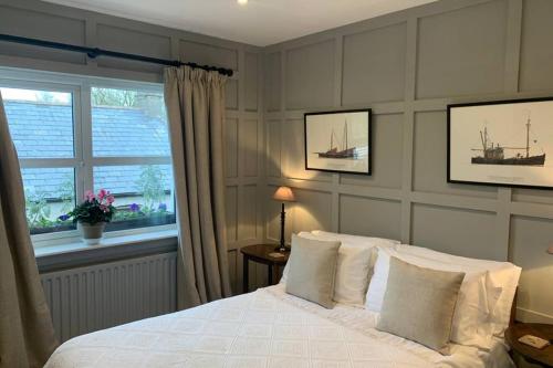 ein Schlafzimmer mit einem weißen Bett und einem Fenster in der Unterkunft The Lambing Shed at Walkmill Farm in Bushmills