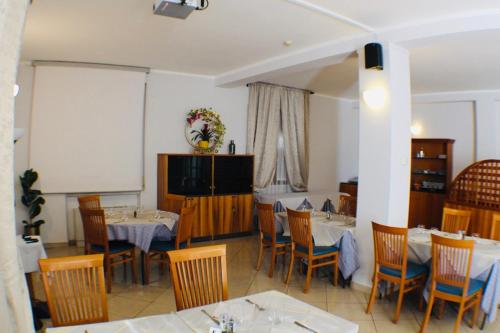 a dining room with two tables and chairs at Hotel Europa Milano in Rosate