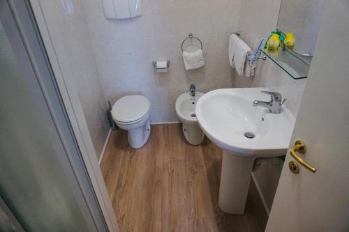 a white bathroom with a toilet and a sink at Hotel Europa Milano in Rosate