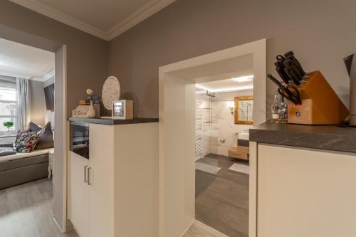 a kitchen with white cabinets and a bathroom at Ferienwohnungen am Wintergarten in Gera