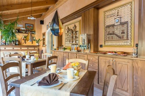 カステル・ディ・サングロにあるAlbergo Il Giardino del Rioのテーブルと椅子、キッチン付きのレストラン
