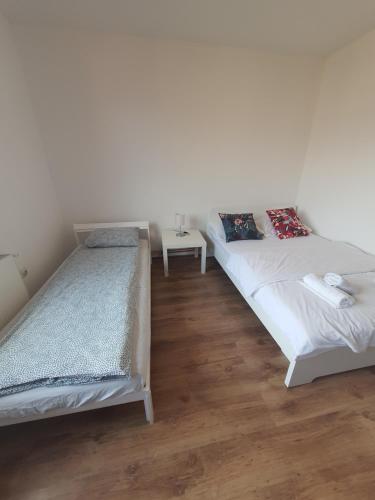 a bedroom with two beds and a table at Kucica u Šumi in Užice