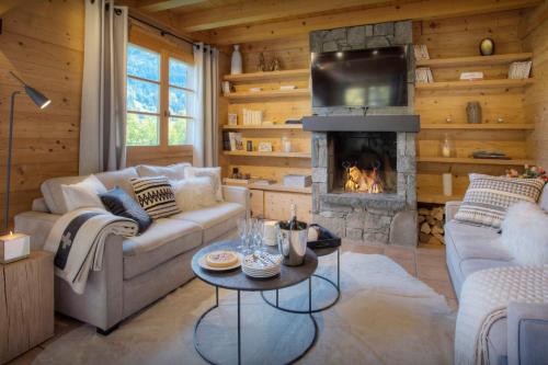 a living room with a couch and a fireplace at Chalet Cosyneige - OVO Network in La Clusaz