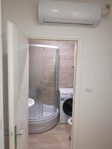a bathroom with a sink and a washing machine at STAN na DAN PEX FREE PARKING in Vranje