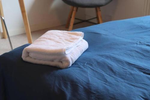 biały ręcznik leży na łóżku w obiekcie Struer Town Rooms w mieście Struer