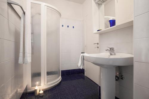 a white bathroom with a sink and a shower at Casa Marco in Nago-Torbole