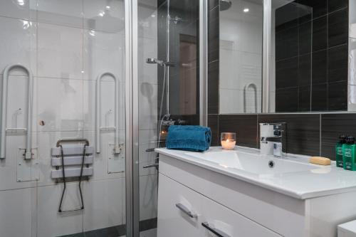 een witte badkamer met een wastafel en een douche bij Serenity by Intiholidays in Quarteira