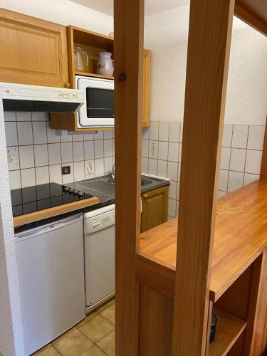 une cuisine avec une cuisinière et un micro-ondes dans l'établissement Parenthèse à la montagne, à Bessans