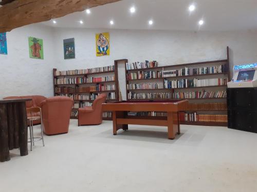 uma biblioteca com várias prateleiras cheias de livros em Le gîte du bois sebille em Verdelot