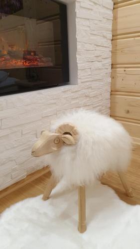a stuffed animal of a white sheep sitting on a rug at Villa Fortuna - Regionalne apartamenty & SPA - Sauna, Grill, Jacuzzi z widokiem na Tatry in Zakopane
