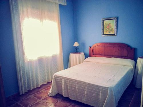 a blue bedroom with a bed and a window at Casa Pilar in Perelló