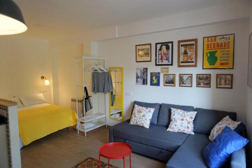 a living room with a blue couch and a bed at Casa Eladia in Logroño