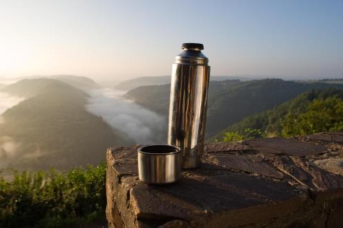 a thermos sitting on top of a rock with a view at Buchnas Landhotel Saarschleife in Mettlach