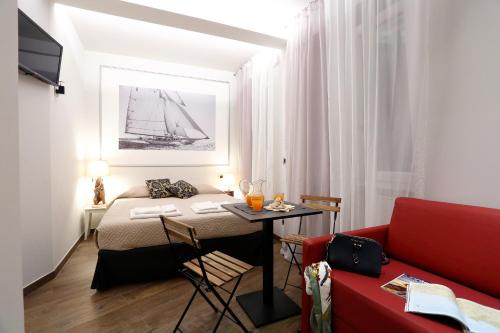 a small room with a bed and a red couch at Gaslini e Sole in Genova
