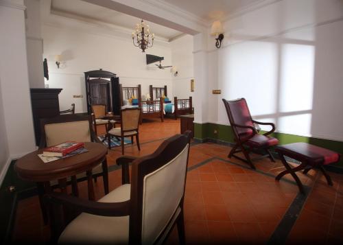 a living room with chairs and a table at Parisons Plantation Experiences by Abad in Mananthavady