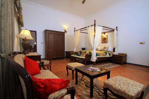 a living room with a bed and a table and chairs at Parisons Plantation Experiences by Abad in Mananthavady