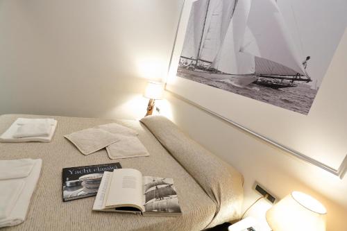 una camera con un letto con un libro e una foto di Gaslini e Sole a Genova