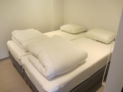 2 camas con almohadas blancas encima de ellas en Au Studio 339 des Terrasses de Malmedy, en Malmedy