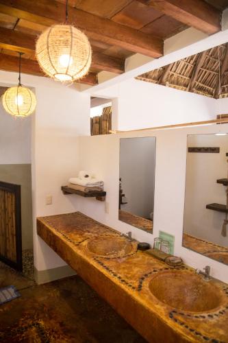a bathroom with two sinks and two mirrors at Un Sueño Cabañas del Pacífico in San Agustinillo