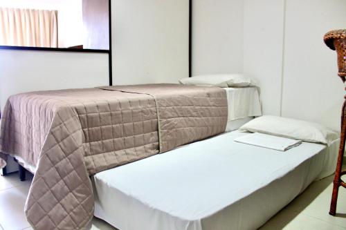 2 camas en una habitación con mesa y silla en Pipa's Bay Apto 208 - Flat em Pipa RN, en Pipa