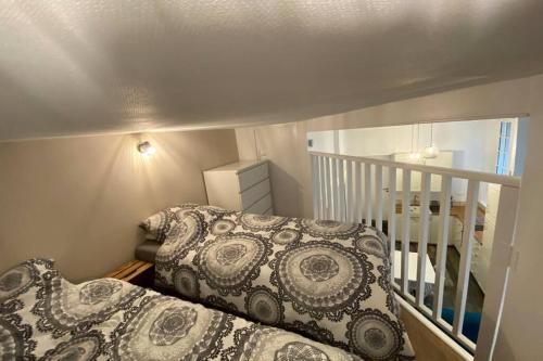 a small bedroom with a bed and a staircase at Le Plongeoir de Bon-Secours in Saint Malo